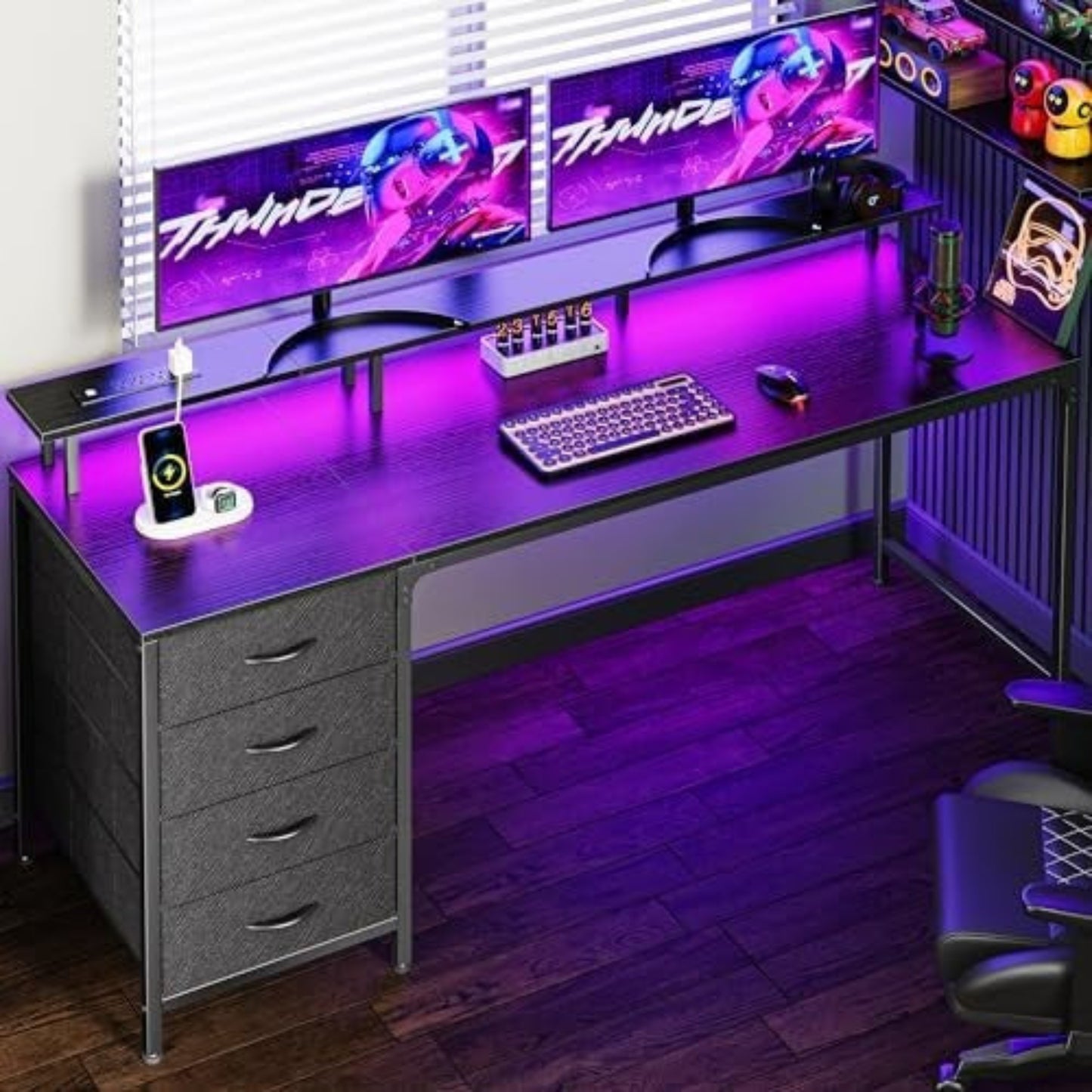 Purple gaming desk with LED backlighting, dual monitor mounts, keyboard tray, and storage drawers